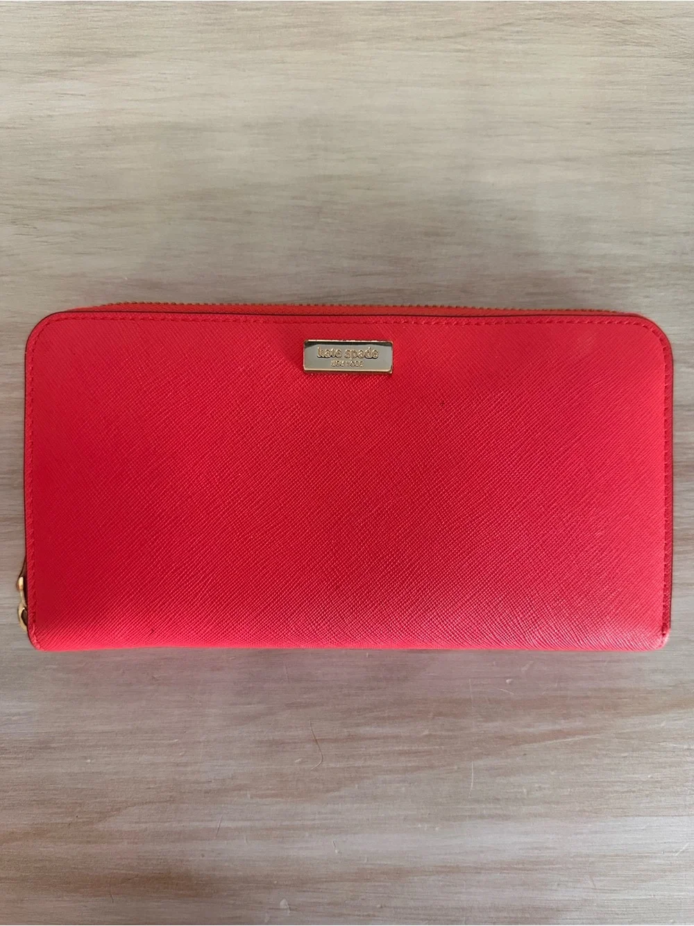 kate spade saffiano zip-around wallet in vibrant red with gold plaque